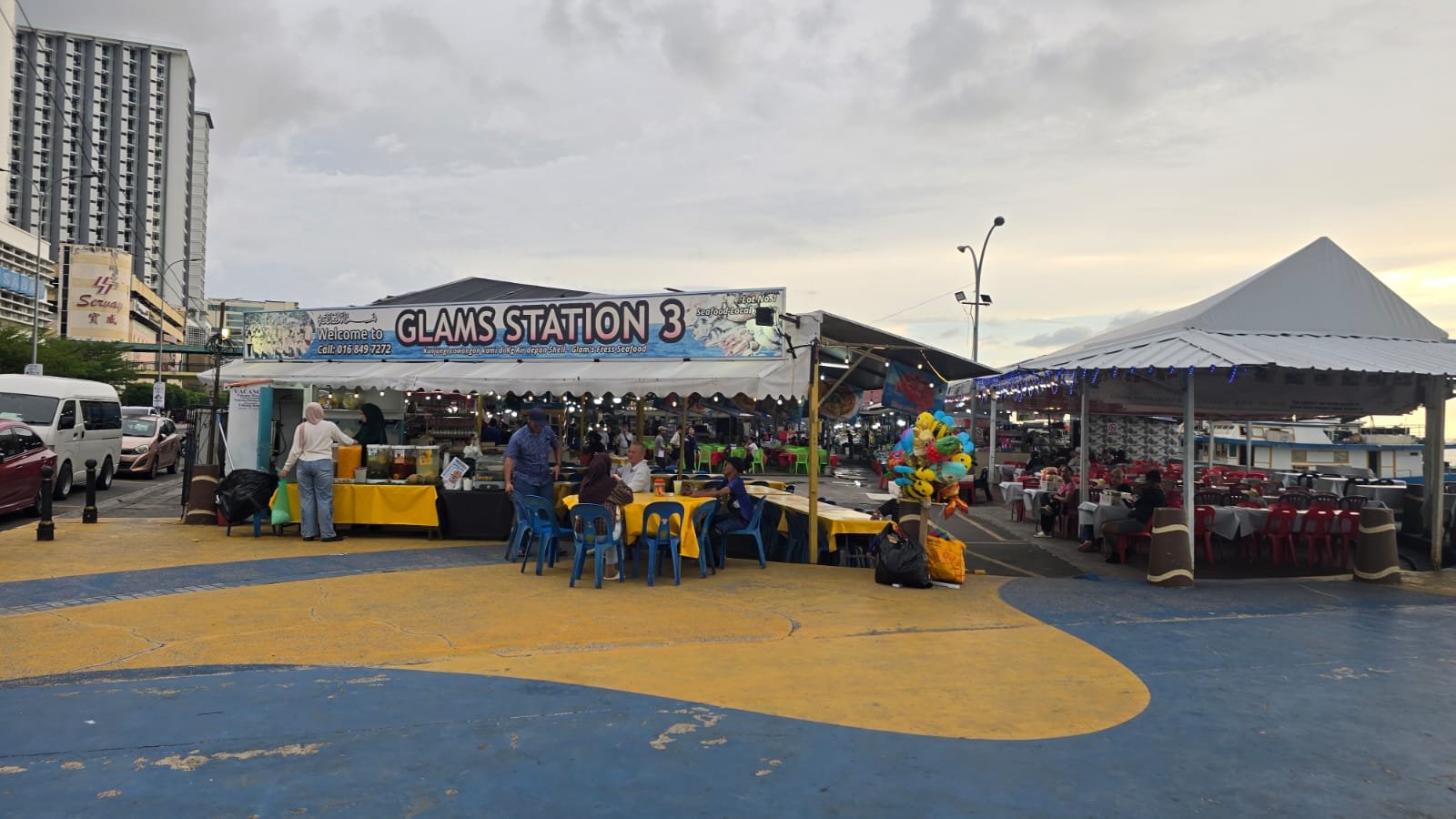 Deretan lapak seafood al fresco seperti Glams Station menjadi tempat favorit menikmati hidangan laut sambil menyaksikan suasana dermaga Kota Kinabalu.