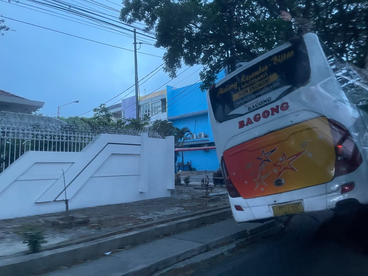 Bus Bagong rute Malang–Kesambon–Blitar masuk ke saluran drainase di bahu Jalan Tumenggung Suryo, Kota Malang, saat hujan pada Sabtu, 24 Oktober 2026.